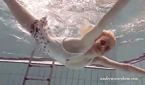 Una ragazza bionda snella nuota sott'acqua