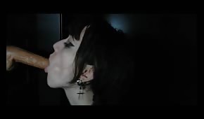 Una ragazza dai capelli neri succhia un cazzo di gomma